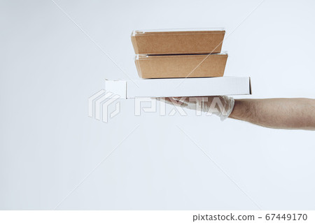 Courier hands in latex gloves giving packed food delivery Courier hands in latex gloves giving packed food delivery 67449170