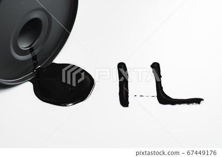 Oil industry concept. Spilled oil from a mini barrel on white background 67449176