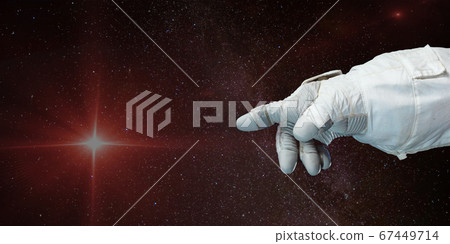 Astronaut hand pointing toward the star with 67449714