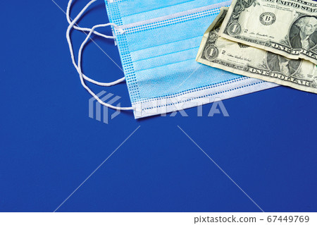 Close up of medical protective masks and american dollar banknotes on blue background 67449769
