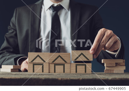 Realtor building houses of wooden blocks Realtor building houses of wooden blocks 67449905