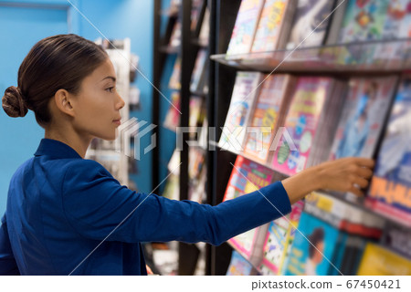 Businesswoman reading magazines at newsstand store of airport or train station. Asian woman shopping at bookstore Businesswoman reading magazines at newsstand store of airport or train station. Asian woman shopping at bookstore 67450421