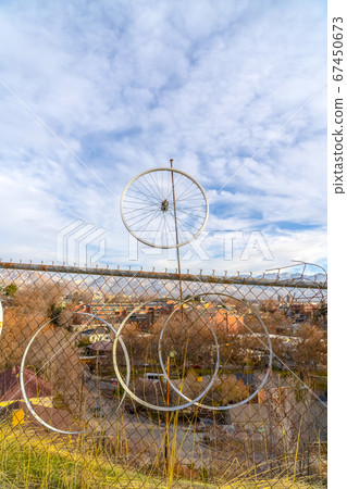Rusty chain link fence with bicycle wheel rims Rusty chain link fence with bicycle wheel rims 67450673