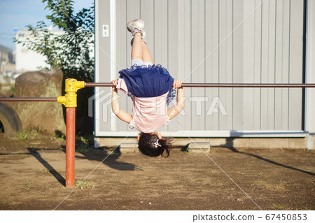 A girl who goes upside down with a horizontal bar 67450853