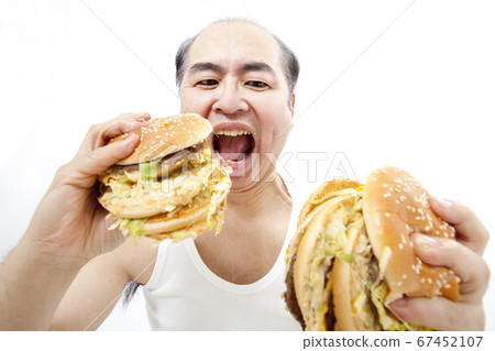 Middle-aged man eating a hamburger 67452107