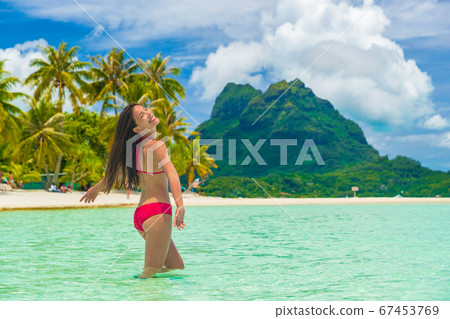 Bora bora luxury vacation travel paradise bikini woman swimming at island in Tahiti, French Polynesia. Popular honeymoon destination holiday in South Pacific, Oceania Bora bora luxury vacation travel paradise bikini woman swimming at island in Tahiti, French Polynesia. Popular honeymoon destination holiday in South Pacific, Oceania 67453769