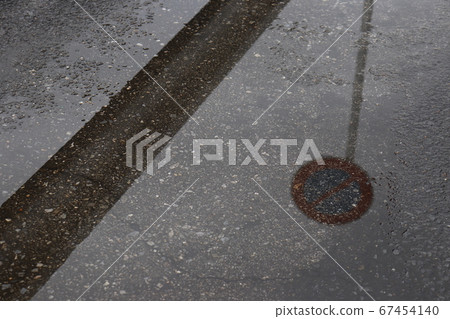 Guardrail and no parking sign reflected in a puddle Guardrail and no parking sign reflected in a puddle 67454140