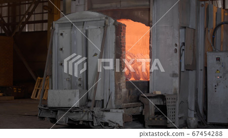 Robotic retractable furnace with red-hot metal workpieces in foundry. Room for manufacture of metal products by casting. Casting shop for gassified models. Heavy industry concept 67454288