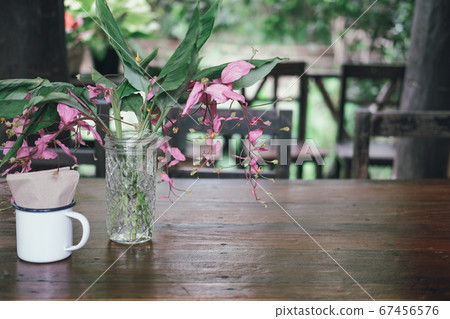 pink flower & green leaves in glass bottle pink flower & green leaves in glass bottle 67456576