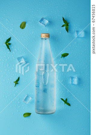 A bottle of ice water, ice cubes, drops and mint A bottle of ice water, ice cubes, drops and mint 67456815
