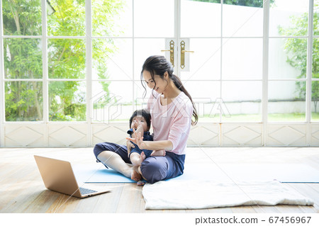 Parents and children doing online yoga at home 67456967