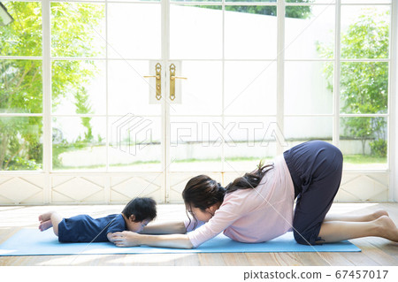 Parents and children doing yoga at home 67457017