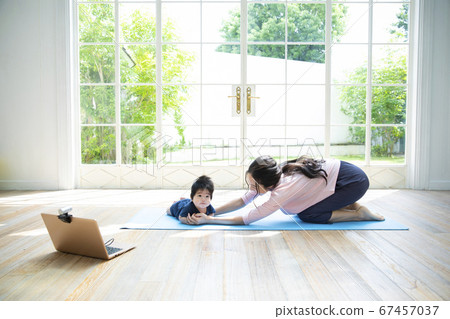 Parents and children doing online yoga at home Parents and children doing online yoga at home 67457037