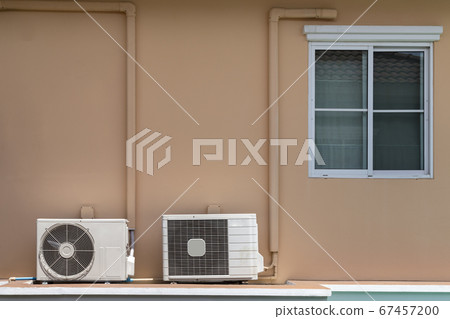 two types of home air conditioner compressor coil installation at the balcony under the window of the house. 67457200