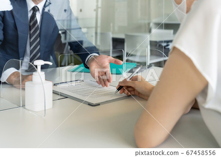 Businessman talking through acrylic partition Infection control social distance 67458556