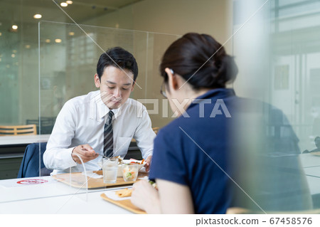 人們在丙烯酸隔板之間進食 人們在丙烯酸隔板之間進食 67458576