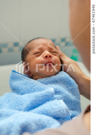 asian father holding and bathing newborn for the first time of life in the morning. asian father holding and bathing newborn for the first time of life in the morning. 67461946