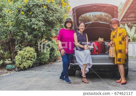 Two senior woman and one adult woman sitting in back of the car with suitcases on car trip. Two senior woman and one adult woman sitting in back of the car with suitcases on car trip. 67462117