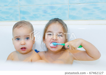 little girls brush their teeth in the bathroom. portrait of children with a toothbrush little girls brush their teeth in the bathroom. portrait of children with a toothbrush 67462127