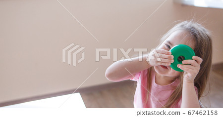child plays with detail from pyramid. girl looks through hole in the wheel. Concept of motor skills development, educational games, childhood, children's day, kindergarten, house arrest copyspace child plays with detail from pyramid. girl looks through hole in the wheel. Concept of motor skills development, educational games, childhood, children's day, kindergarten, house arrest copyspace 67462158
