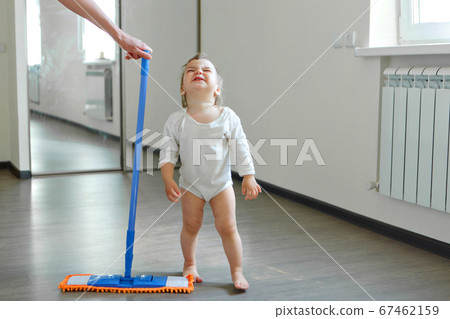 a small child is cleaning the house. Girl sweeps the floor. restoring order in the apartment a small child is cleaning the house. Girl sweeps the floor. restoring order in the apartment 67462159