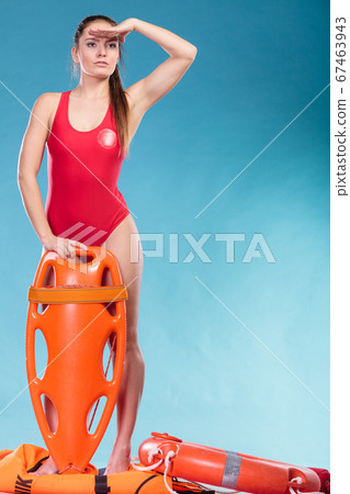 Lifeguard on duty with rescue buoy supervising. 67463943