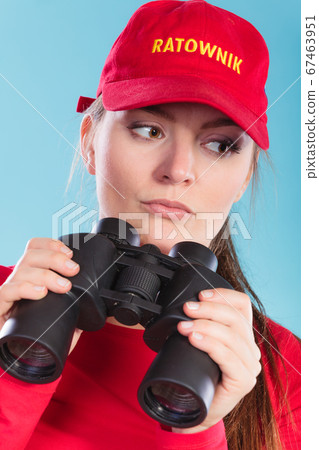 Lifeguard on duty supervising with binoculars. Lifeguard on duty supervising with binoculars. 67463951