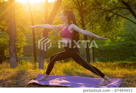 Woman is doing exercise on beautiful nature in the background 67464951