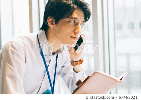 A young man calling with a notebook A young man calling with a notebook 67465021