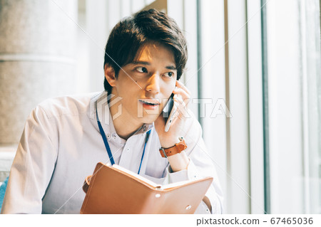 A young man calling with a notebook 67465036