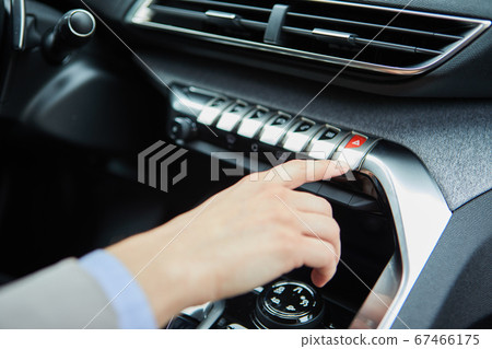 hand presses the buttons in the car 67466175
