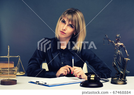 A young fair woman judge works in her office. 67468884