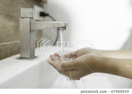 Close-up of washing hands in the sink to prevent germs. 67468939