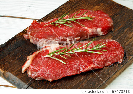 Barbecue veal steaks with rosemary on wooden board 67470218