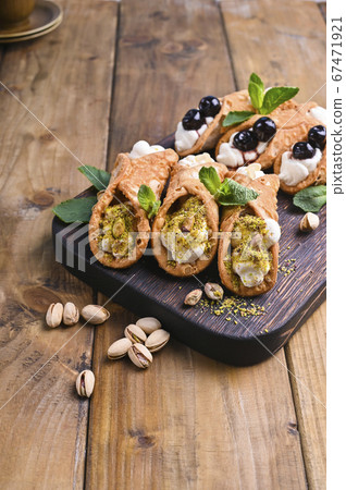 Cannoli Sicily. Traditional Italian sweet with ricotta and various fillings. Food on a wooden 67471921