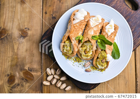 Cannoli Sicily. Traditional Italian sweet with ricotta and various fillings. Food on a wooden 67472015