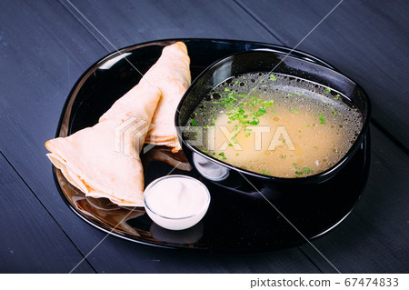 Fresh fish soup with egg in a black deep dish with 67474833