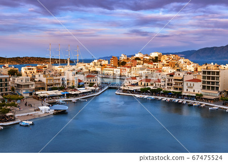 Colorful view of Voulismeni lake and Agios Nikolaos town on Crete island, Greece at sunset with beautiful clouds on blue sky 67475524
