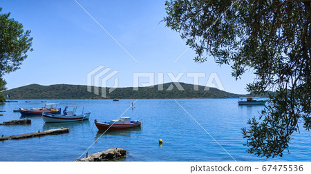 View of lagoon with anchored fishermen's boats on a sunny summer day on Crete island, Greece View of lagoon with anchored fishermen's boats on a sunny summer day on Crete island, Greece 67475536