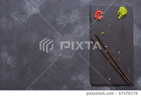 Chopsticks on a black stone on a gray concrete background 67476578