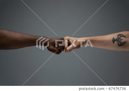 Racial tolerance. Respect social unity. African and caucasian hands gesturing isolated on gray studio background 67476736