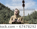 a man with binoculars in his hands looks into the distance. abandoned old railway  67478292