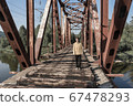 man stands on an abandoned railway bridge.  67478293
