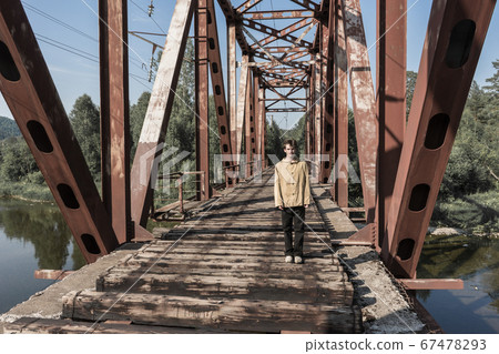 man stands on an abandoned railway bridge. man stands on an abandoned railway bridge. 67478293