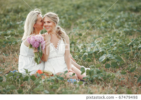 Mother with beautiful daughter in a autumn field Mother with beautiful daughter in a autumn field 67479498