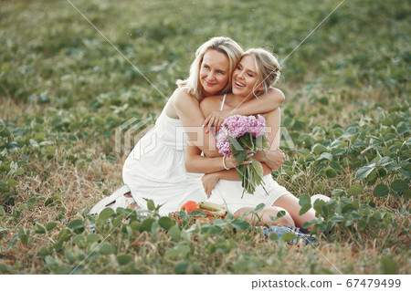 Mother with beautiful daughter in a autumn field Mother with beautiful daughter in a autumn field 67479499