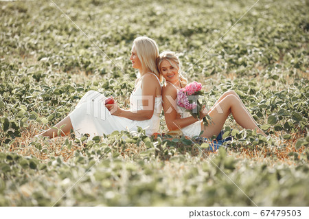 Mother with beautiful daughter in a autumn field Mother with beautiful daughter in a autumn field 67479503