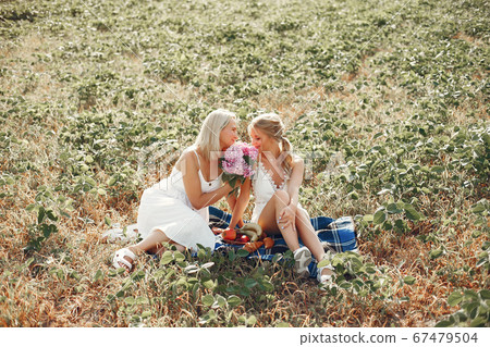 Mother with beautiful daughter in a autumn field Mother with beautiful daughter in a autumn field 67479504