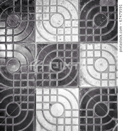 A black and white photo of black and white dirty stone tiles used for covering floor 67479591