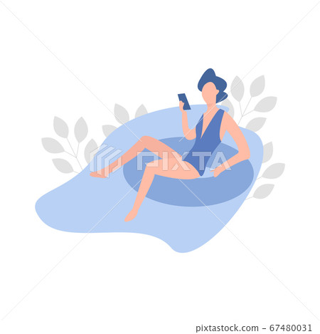 Young Woman Sunbathing in the Swimming Pool and playing with her phone 67480031